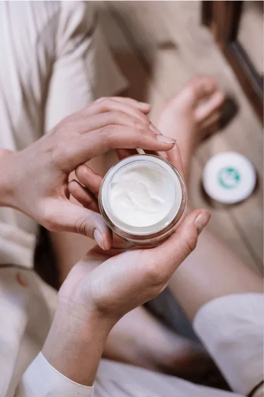 A woman holding a rejuvenating face cream/mask 